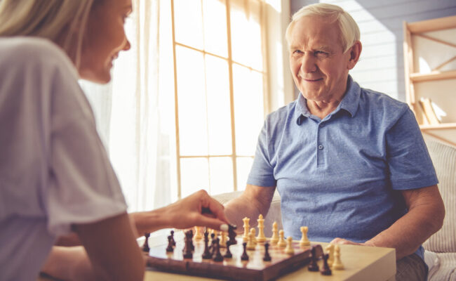 Home Health Aide Playing Chess with Client